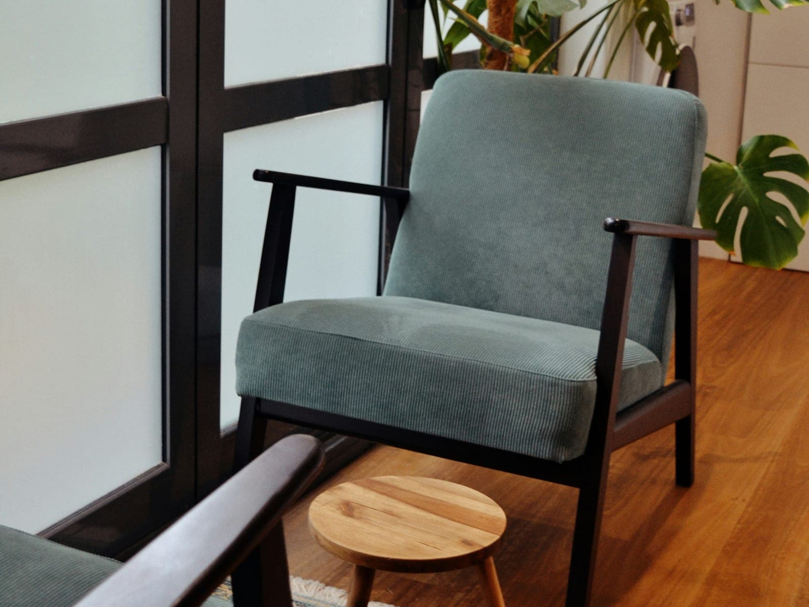 A calm office with a teal armchair and plants